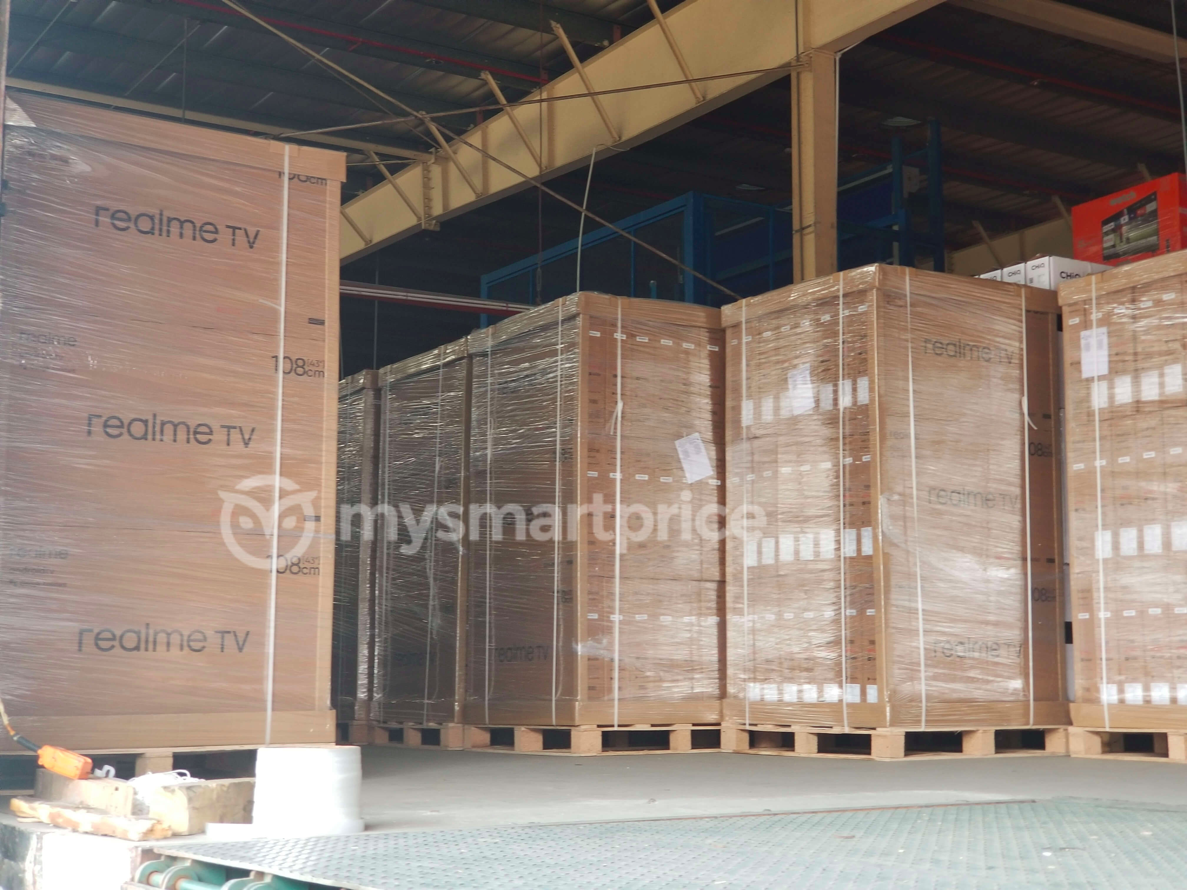 Realme TV retail packaging boxes stacked up in a warehouse